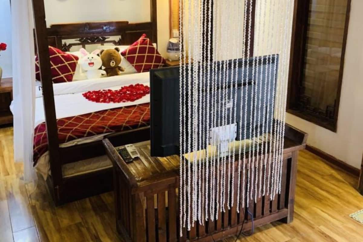 A room with a bed, a TV, and a decorative curtain.