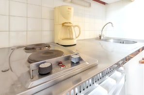 A kitchen with a coffee maker, a sink, and a stovetop. - Homerez - Apartment in La Plagne (La plagne)