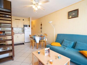 Un espacio habitable compacto con kitchenette, comedor y sofá.