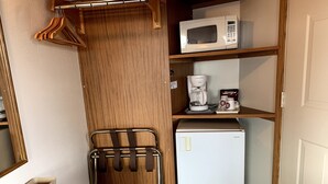 Una cuineta compacta amb microones, cafetera i nevera.