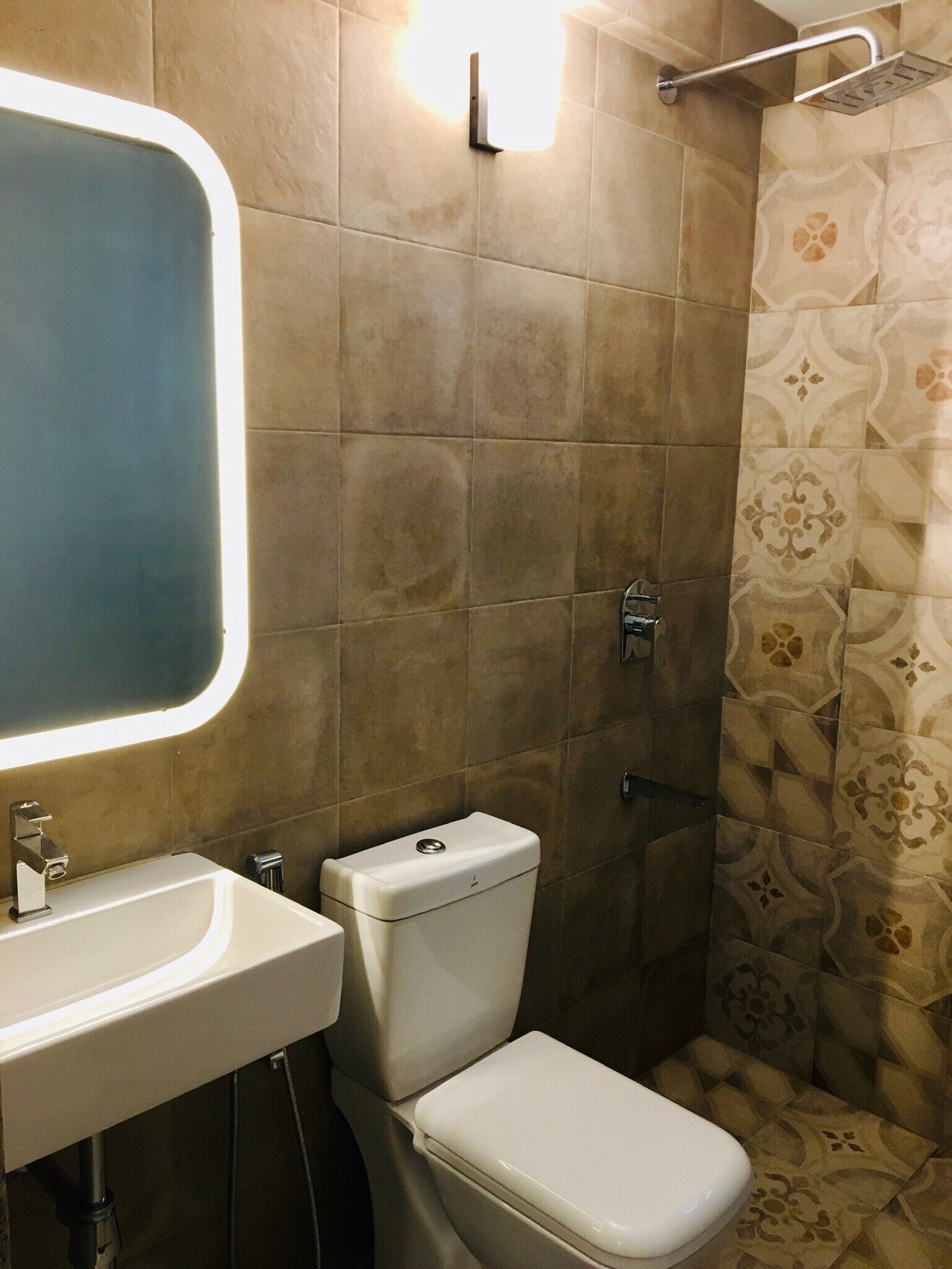 Un baño con lavamanos blanco, inodoro y ducha.