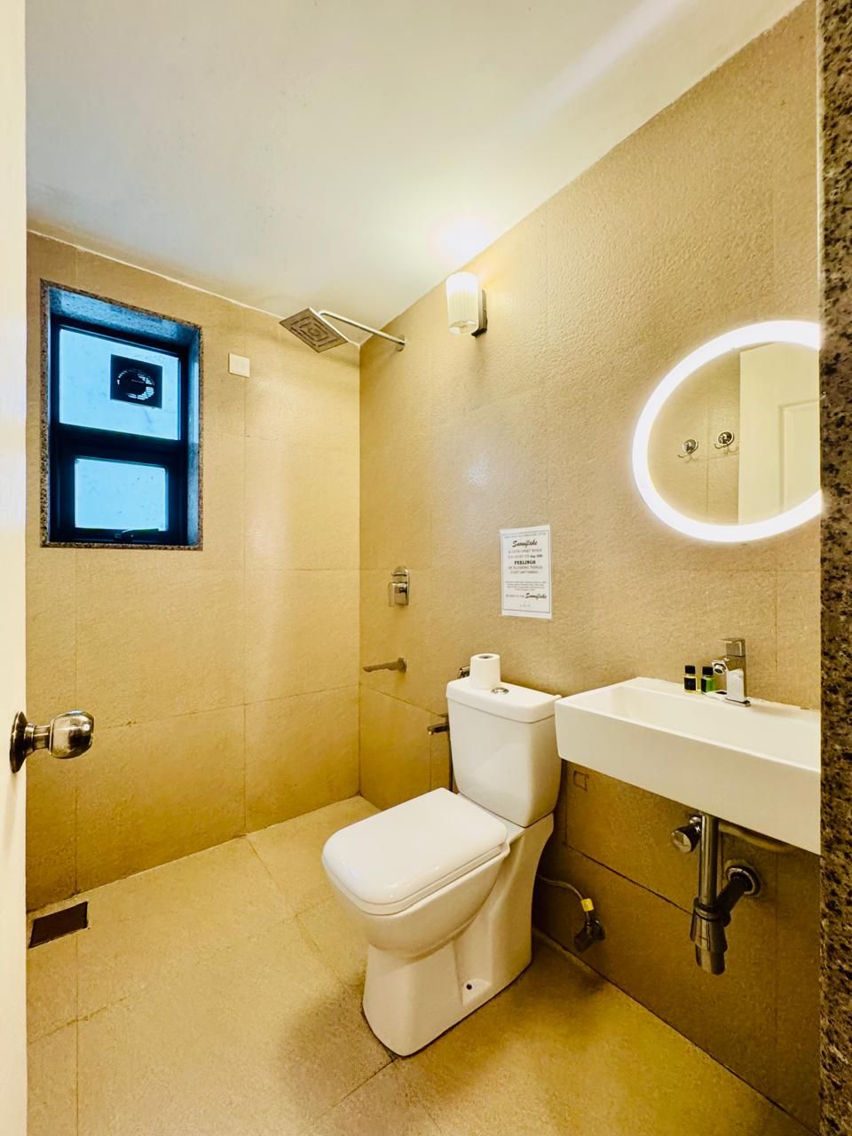 A compact bathroom with a toilet, sink, and a small window.