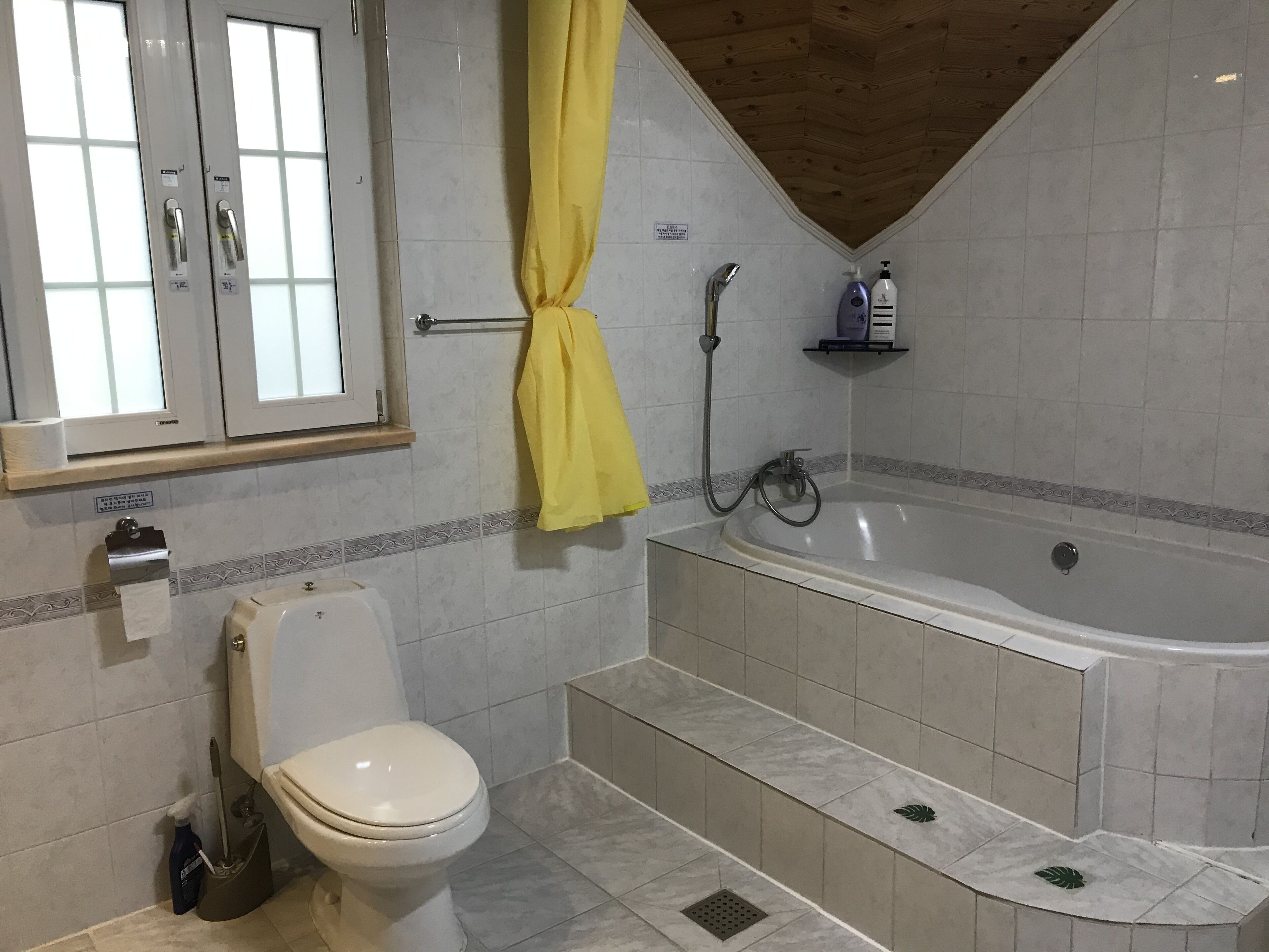 A bathroom with a toilet, a bathtub, and a shower.