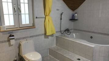 A bathroom with a toilet, a bathtub, and a shower.