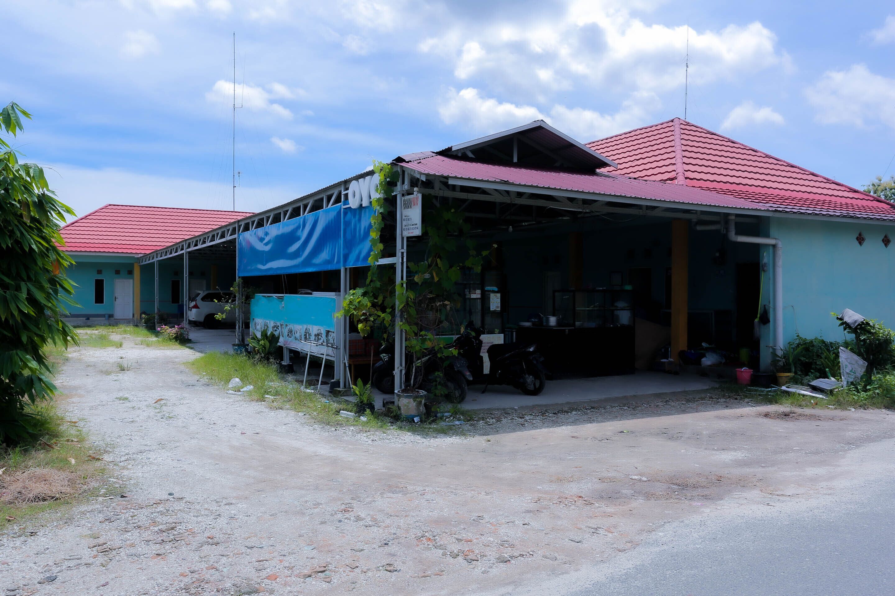 A two-story building with a red roof and a blue awning.