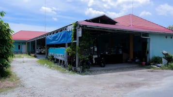 A two-story building with a red roof and a blue awning.