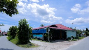 A building with a red roof, a covered porch, and a sign that reads "OYO". - OYO 2692 Penginapan Mba Ros (Banjarbaru)