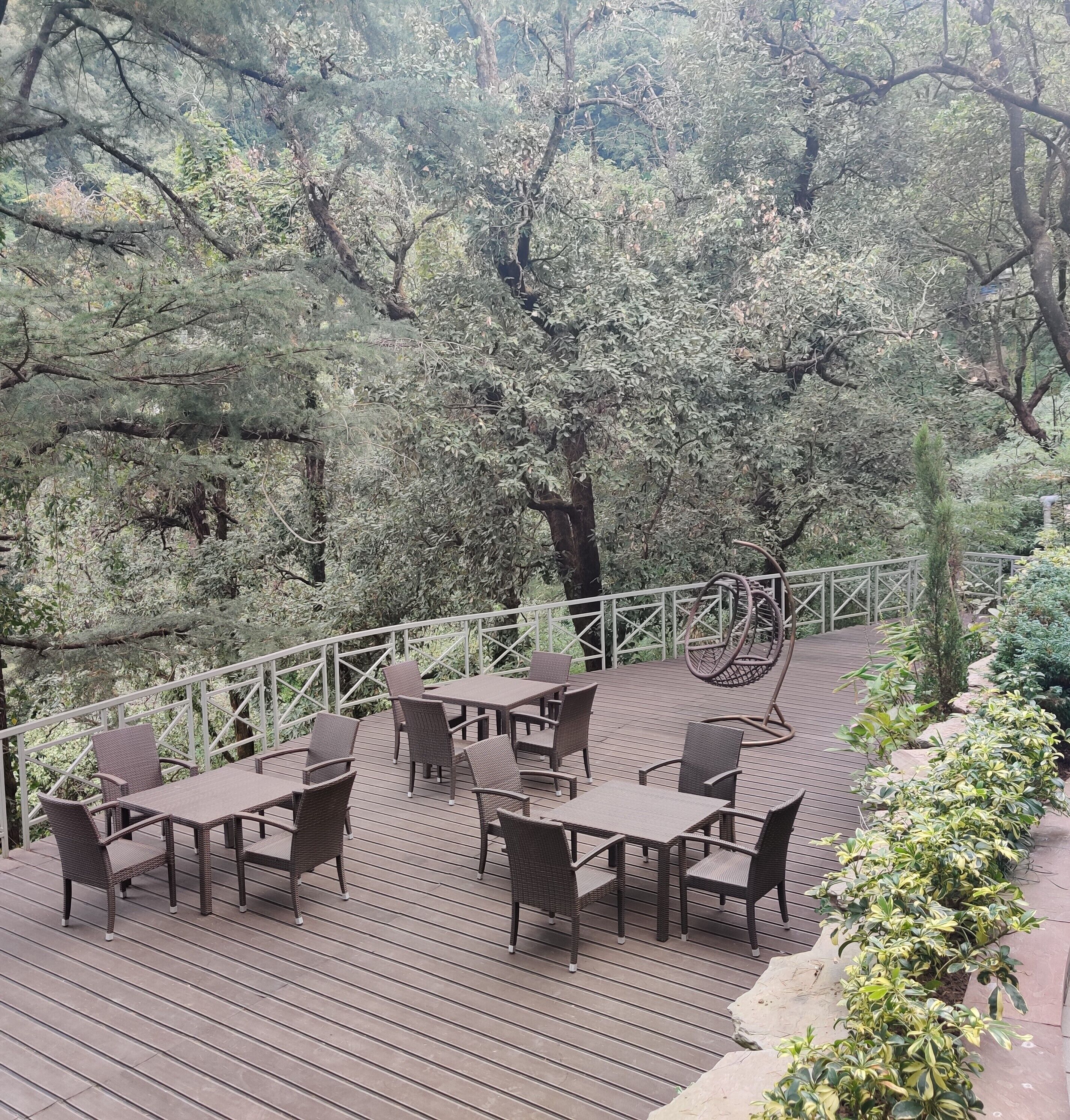 A deck with outdoor seating and a view of the surrounding trees.