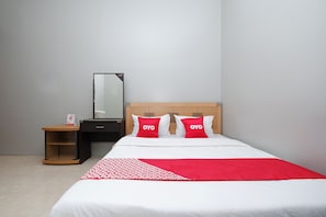 A hotel room with a bed, a nightstand, a mirror, and a red and white patterned throw blanket. - OYO 2737 D'KostNearKraton mangkunegaran (Surakarta)