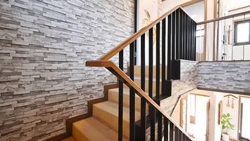 A staircase with a stone wall on one side and a wooden railing.
