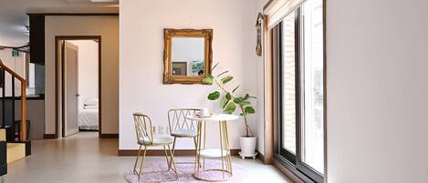A modern interior with a dining area, a large mirror, and a potted plant.
