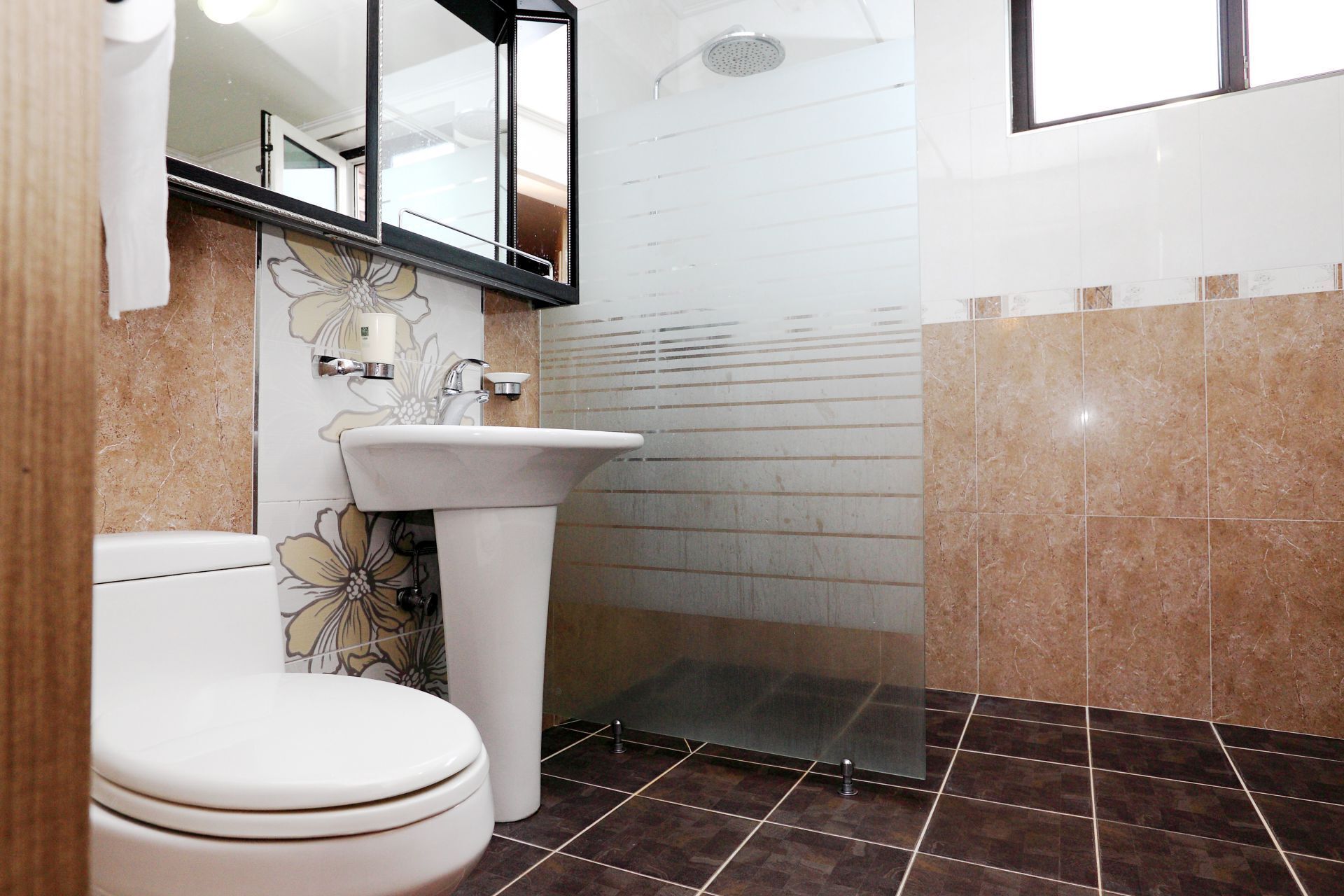 A bathroom with a toilet, sink, and shower.