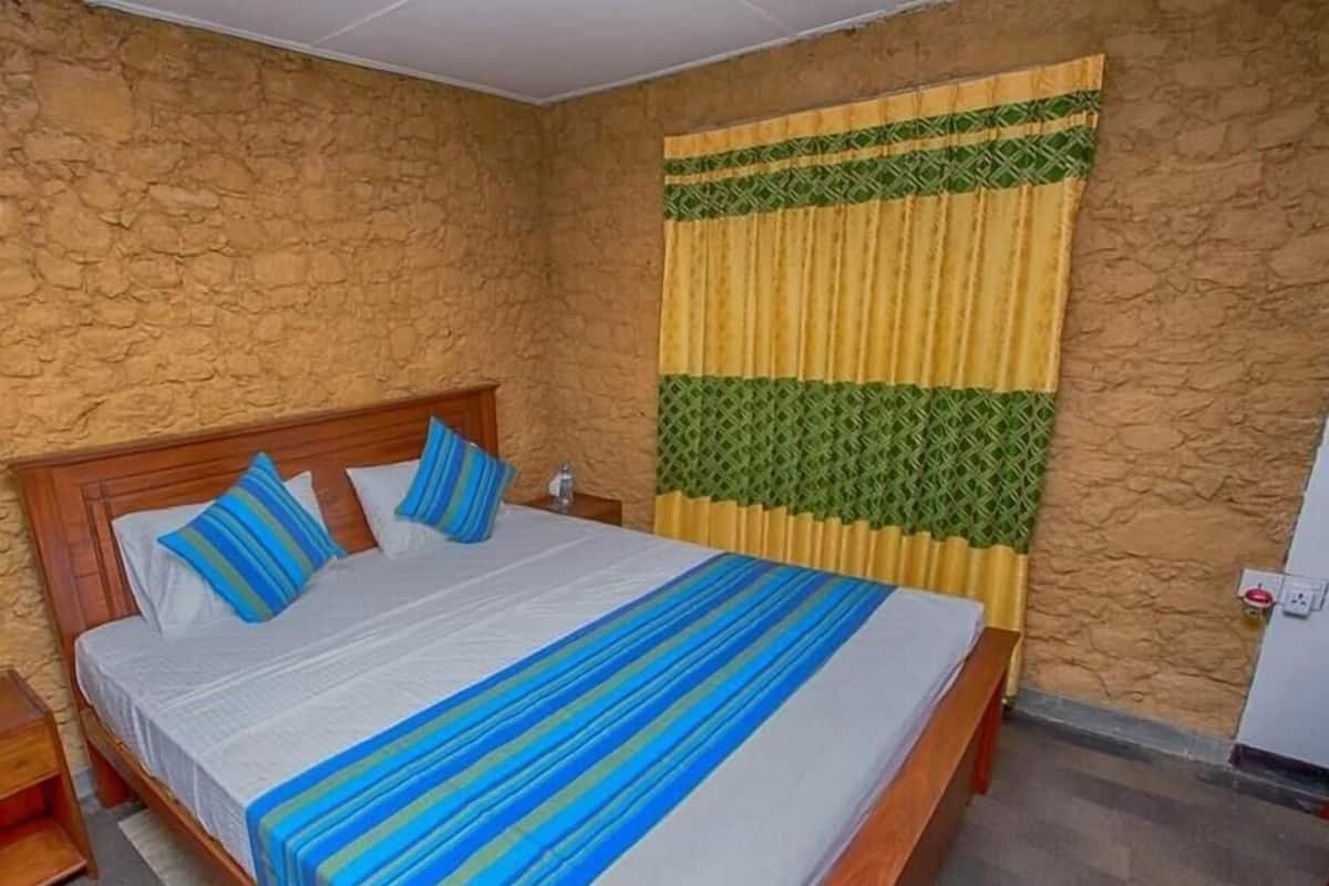 A bedroom with a wooden bed, a nightstand, and a wall with a textured pattern.