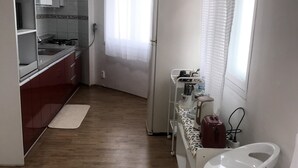 A compact kitchen with a sink, a refrigerator, and a countertop with various items. - Gwangju Songjeong Station Guesthouse - Hostel (Gwangju)