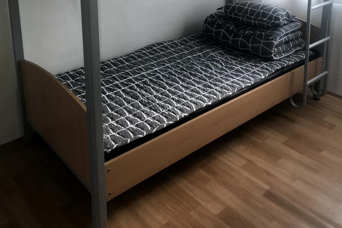 A bunk bed with a lower bunk and a mattress with a geometric pattern.