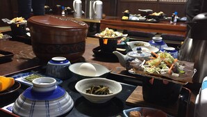 A traditional Japanese meal setup with various dishes, including a teapot, bowls, and chopsticks. - Shirakawago Gassho-house YOKICHI (Shirakawa)