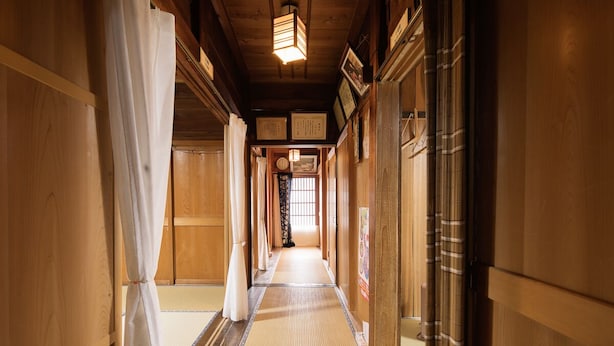 A traditional Japanese hallway with tatami flooring, wooden walls, and sliding doors. - Shirakawago Gassho-house YOKICHI (Shirakawa)