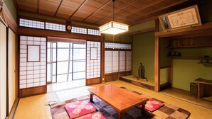 Een traditionele Japanse kamer met tatami vloerbedekking, een houten tafel en shoji schermen.