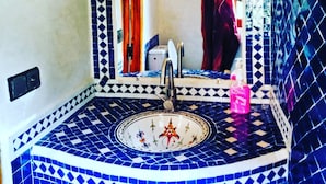 A bathroom with a sink, mirror, and tiled walls. - inn the Fibula of Dades (Boumalne Dadès)