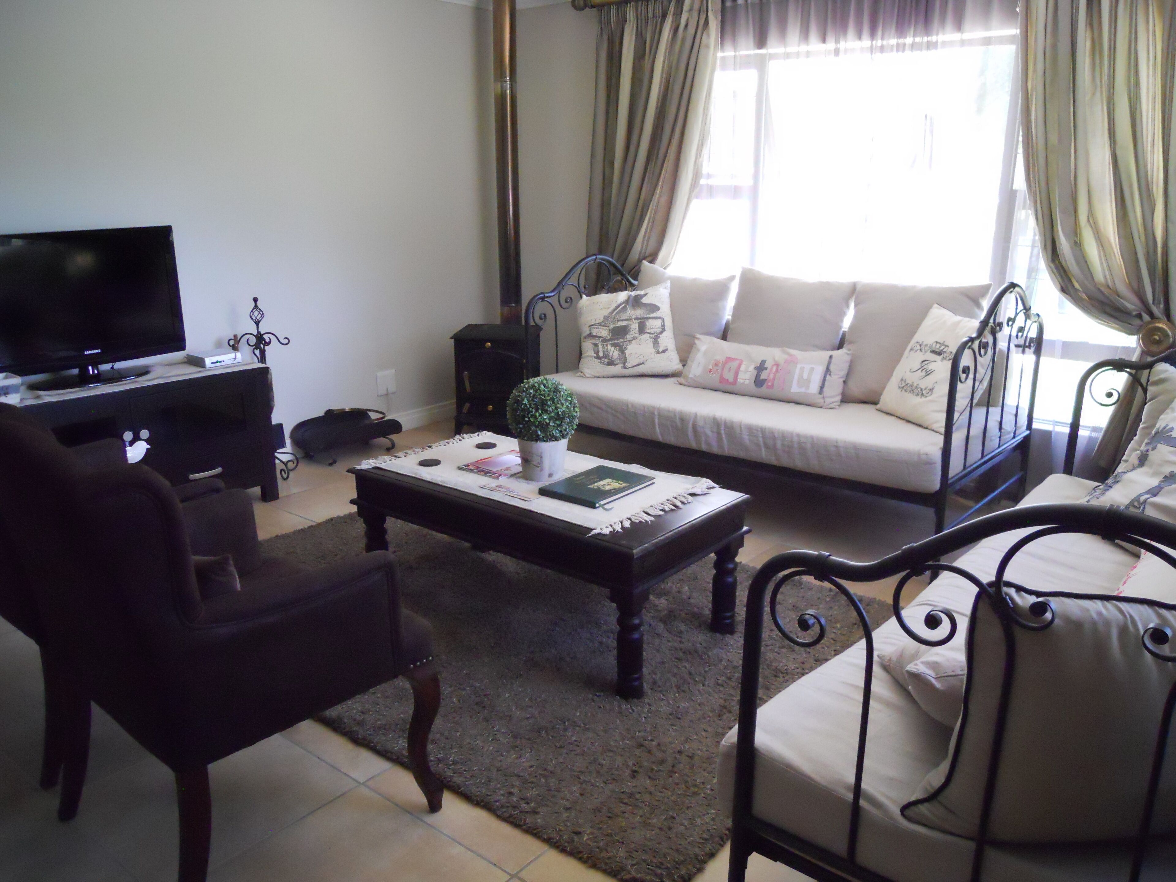 A living room with a sofa, a coffee table, a TV, and a small plant.