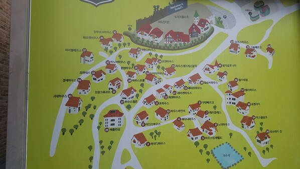 A map of a residential area with numbered houses and a central park. - German Village Gelbe Haus (Namhae)