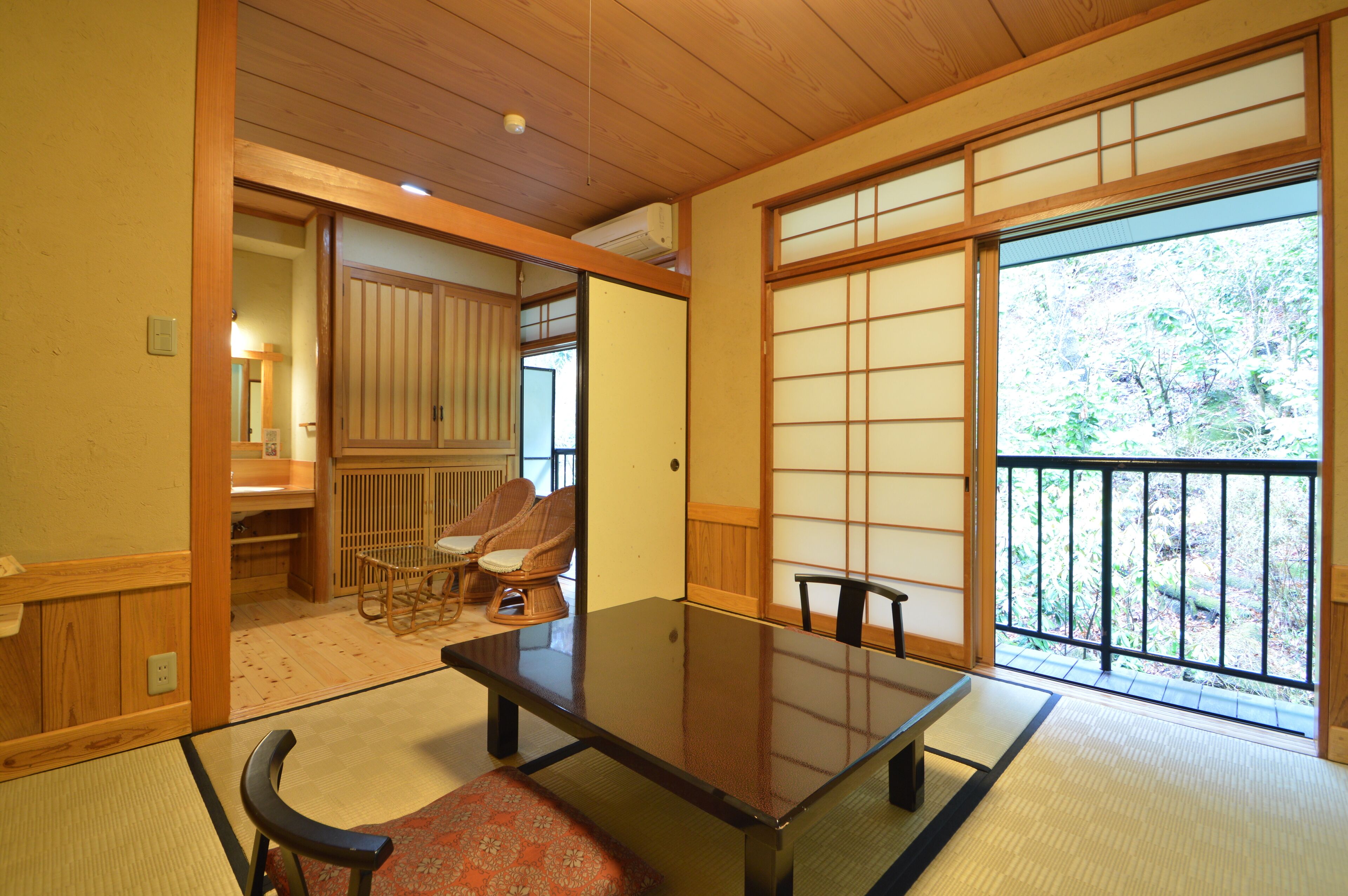 A traditional Japanese room with tatami flooring, a low table, and sliding doors.
