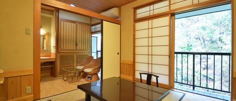 A traditional Japanese room with tatami flooring, a low table, and sliding doors.