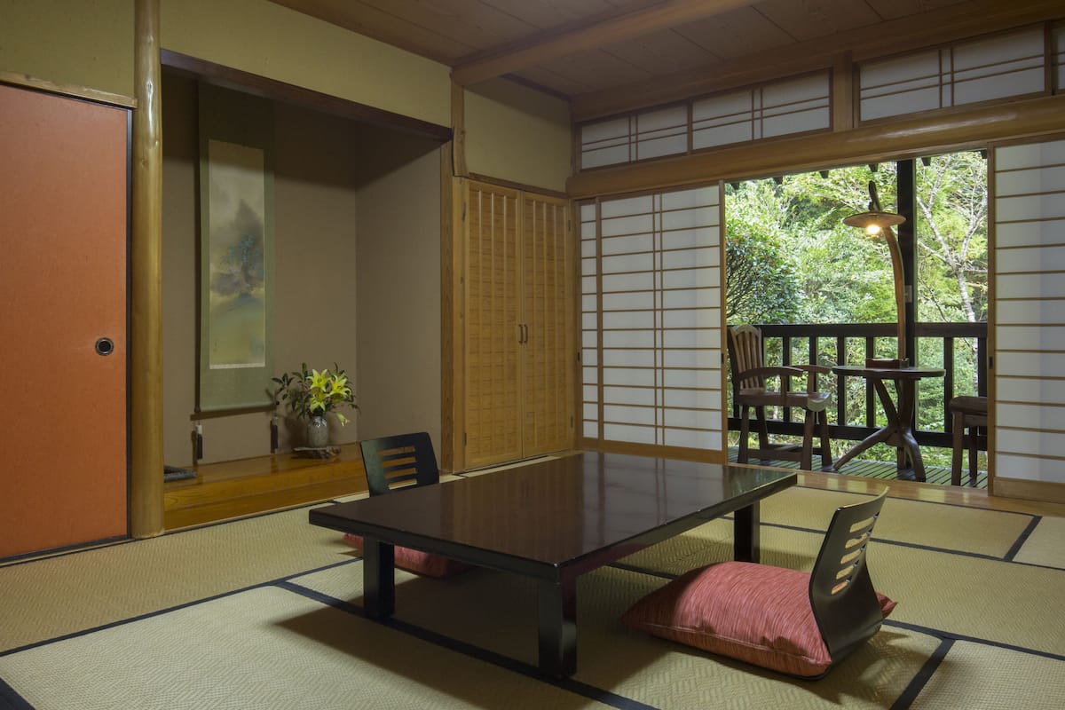 Ein traditioneller japanischer Raum mit Tatami-Böden, einem niedrigen Tisch und Schiebetüren.