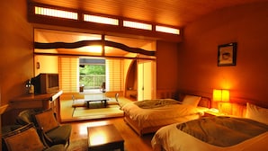 A traditional Japanese-style room with tatami flooring, a low wooden ceiling, and sliding doors leading to a balcony. There are two beds with white bedding, a small table, and a sofa with cushions. - Kurokawa Onsen Okunoyu (Minamioguni)