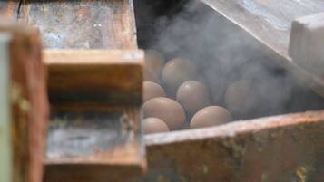 A close-up of eggs in a wooden container with steam rising from them.