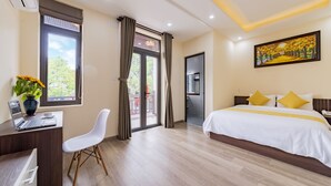 A hotel room with a bed, desk, chair, and a view of the outdoors. - Green Hill Hotel (Da Nang)