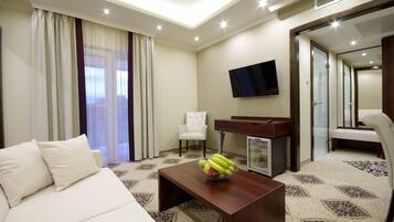 Ein Hotelzimmer mit Bett, Schreibtisch, Stuhl, Fernseher und einer Obstschale.