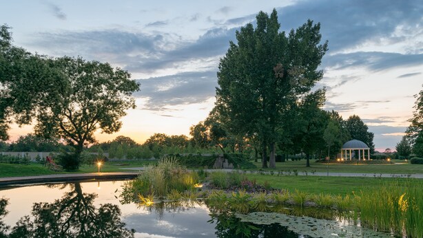 A serene park with a pond, trees, and a gazebo. - Arcanum Hotel (Bekescsaba)