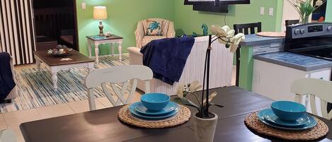 A dining area with a dark wooden table set with blue plates and woven placemats.