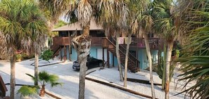Guests can enjoy a balcony with a staircase leading up from the ground level, surrounded by lush tropical vegetation.