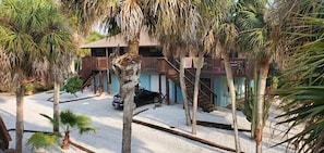 Guests can enjoy a balcony with a staircase leading up from the ground level, surrounded by lush tropical vegetation.