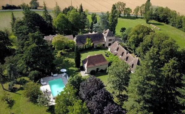 A large estate with multiple buildings, a swimming pool, and a well-maintained lawn.