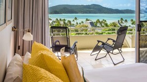 A hotel room with a balcony overlooking a beach and ocean. - Poinciana Lodge 111, Seaview Apartment on Hamilton Island (Hamilton Island)