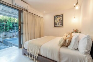 A bedroom with a bed, a window with curtains, a wall-mounted light, and a framed artwork. - 10-bedroom private estate in Seminyak, perfect for large groups, family gatherings, retreats, and celebrations. Enjoy daily breakfast, a private chef, airport transfers, complimentary massages, housekeeping, and a dedicated driver. (Seminyak)