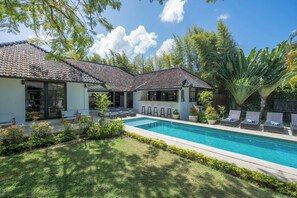 A modern house with a swimming pool, surrounded by lush greenery and a clear blue sky. - 10-bedroom private estate in Seminyak, perfect for large groups, family gatherings, retreats, and celebrations. Enjoy daily breakfast, a private chef, airport transfers, complimentary massages, housekeeping, and a dedicated driver. (Seminyak)