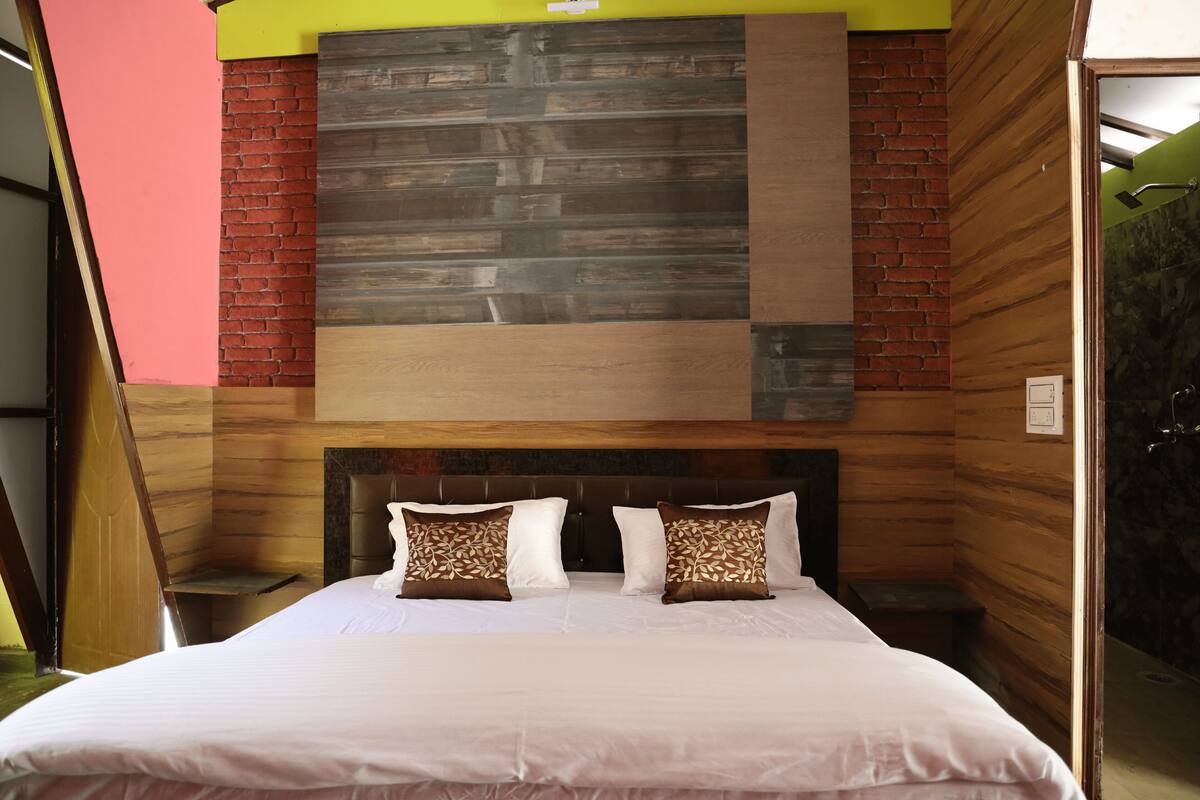 Una habitación con una cama, un cabecero con panel de madera y una pared de ladrillo.