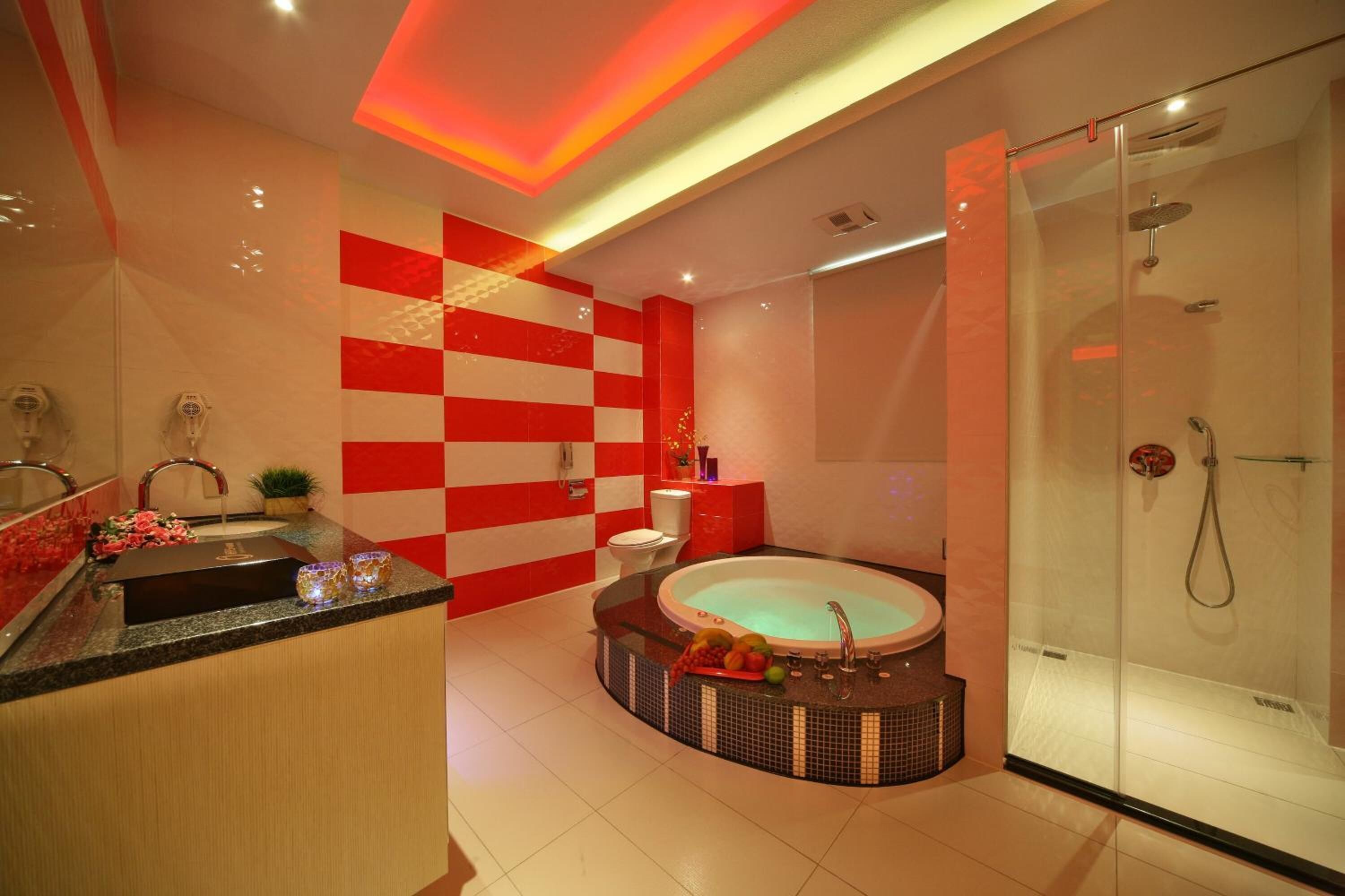 A modern bathroom with a glass-enclosed shower, a freestanding bathtub, and a vanity with a sink and mirror.