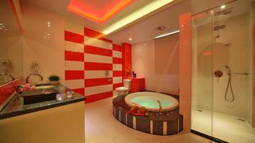 A modern bathroom with a glass-enclosed shower, a freestanding bathtub, and a vanity with a sink and mirror.