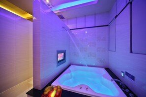 A modern spa room with a hot tub, a digital control panel, and a fruit bowl on the counter. - Shining Motel (Taichung)