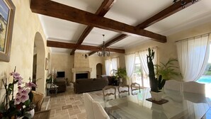 Amplia sala de estar con chimenea, asientos cómodos y una mesa de centro de vidrio.