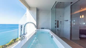 A modern bathroom with a large bathtub, a shower area, and a glass-enclosed shower.