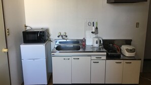 A compact kitchen with a refrigerator, microwave, sink, and a coffee maker. - Stay inn Blue (Goto)