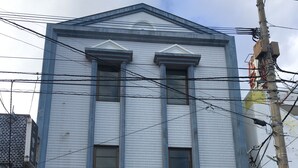 A building with a sign reading "Stay inn Blue" and a staircase leading to the entrance. - Stay inn Blue (Goto)