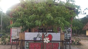 A rustic wooden structure with a banner reading "Linapacan Youth Camp" and a heart symbol.