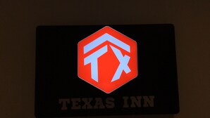 A sign with a logo and the text "TEXAS INN".